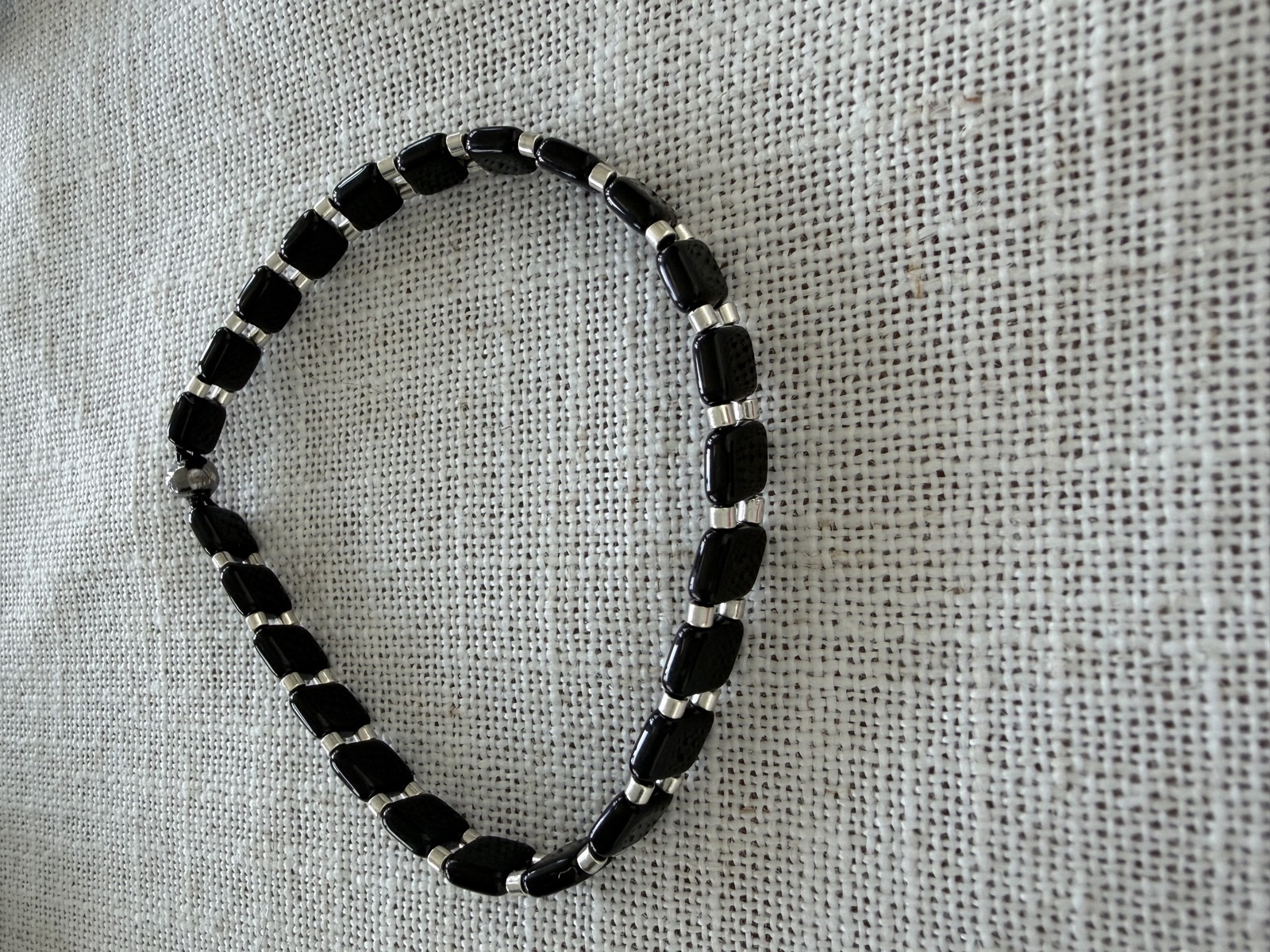 Onyx and silver men's bracelet on linen
