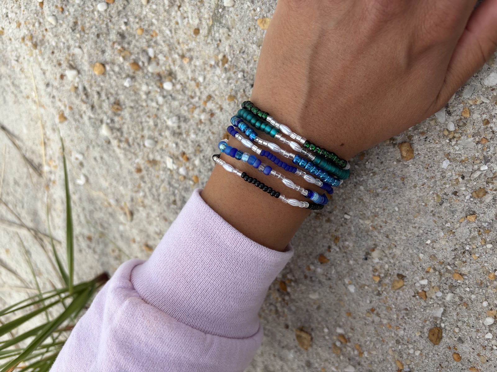 Stacked women's bracelets in blue and teal beads