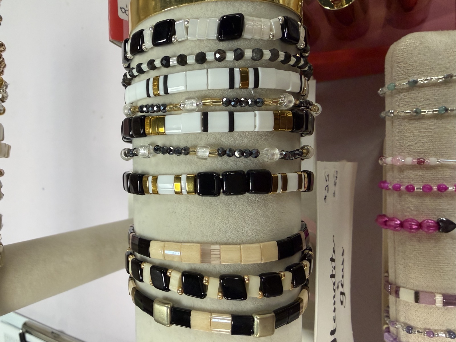 Display rack of black, white and gold tile bracelets
